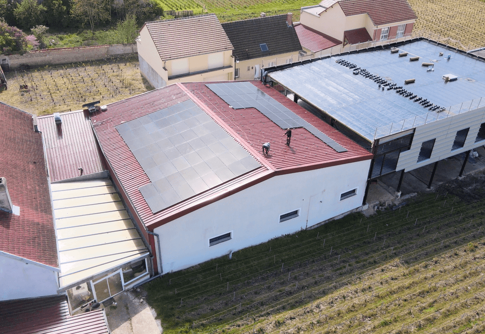 Personnel chargé de l'installation des panneaux solaires sur un entrepôt